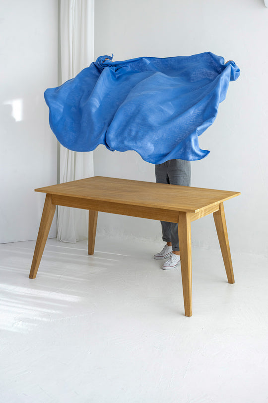 Women serves blue linen tablecloth
