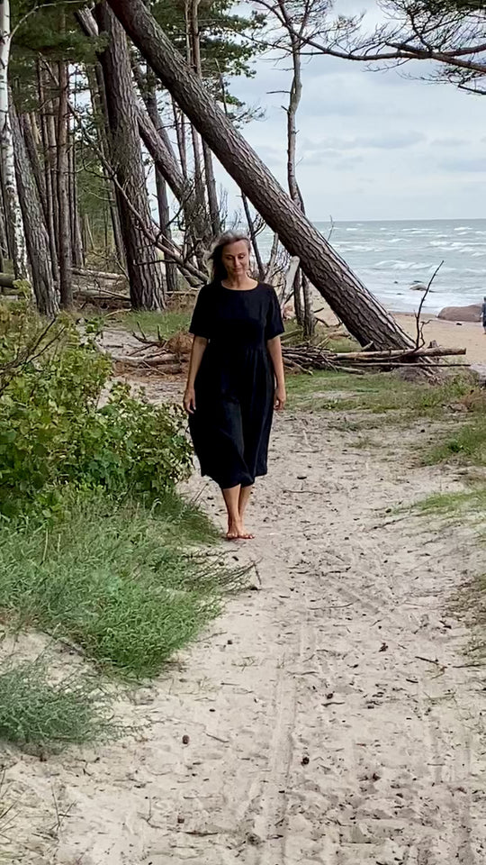 Women demonstrates linen black dress made by Daily Linen