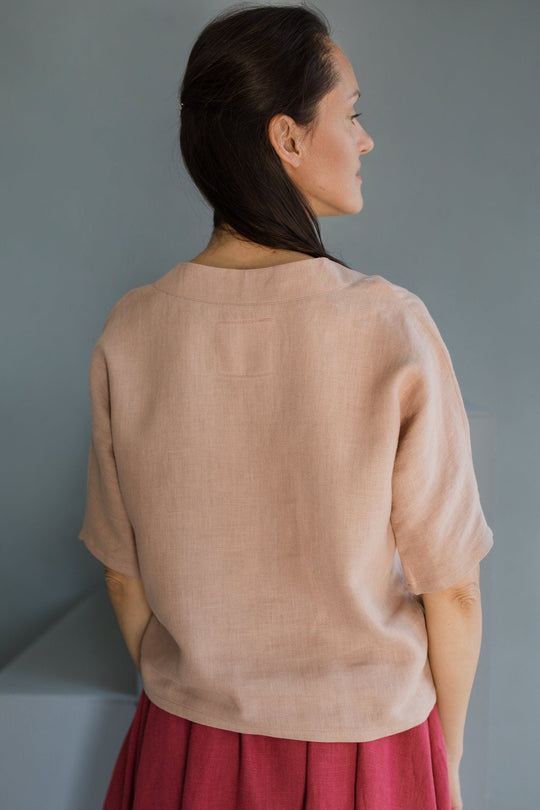 Women wears boxy linen top in powder color