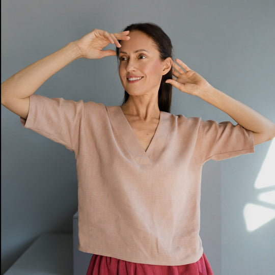 Women wears boxy linen top in powder color