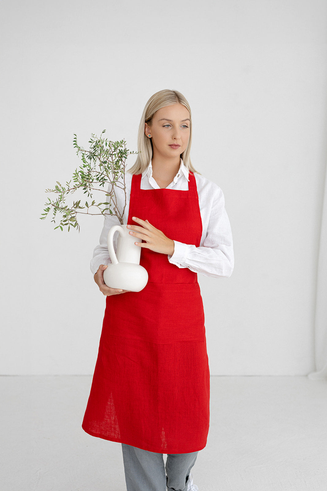 Women wears linen bib apron in red color made by Daily Linen