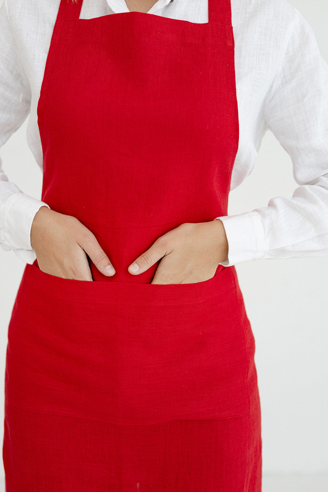 Women wears linen bib apron in red color made by Daily Linen 1