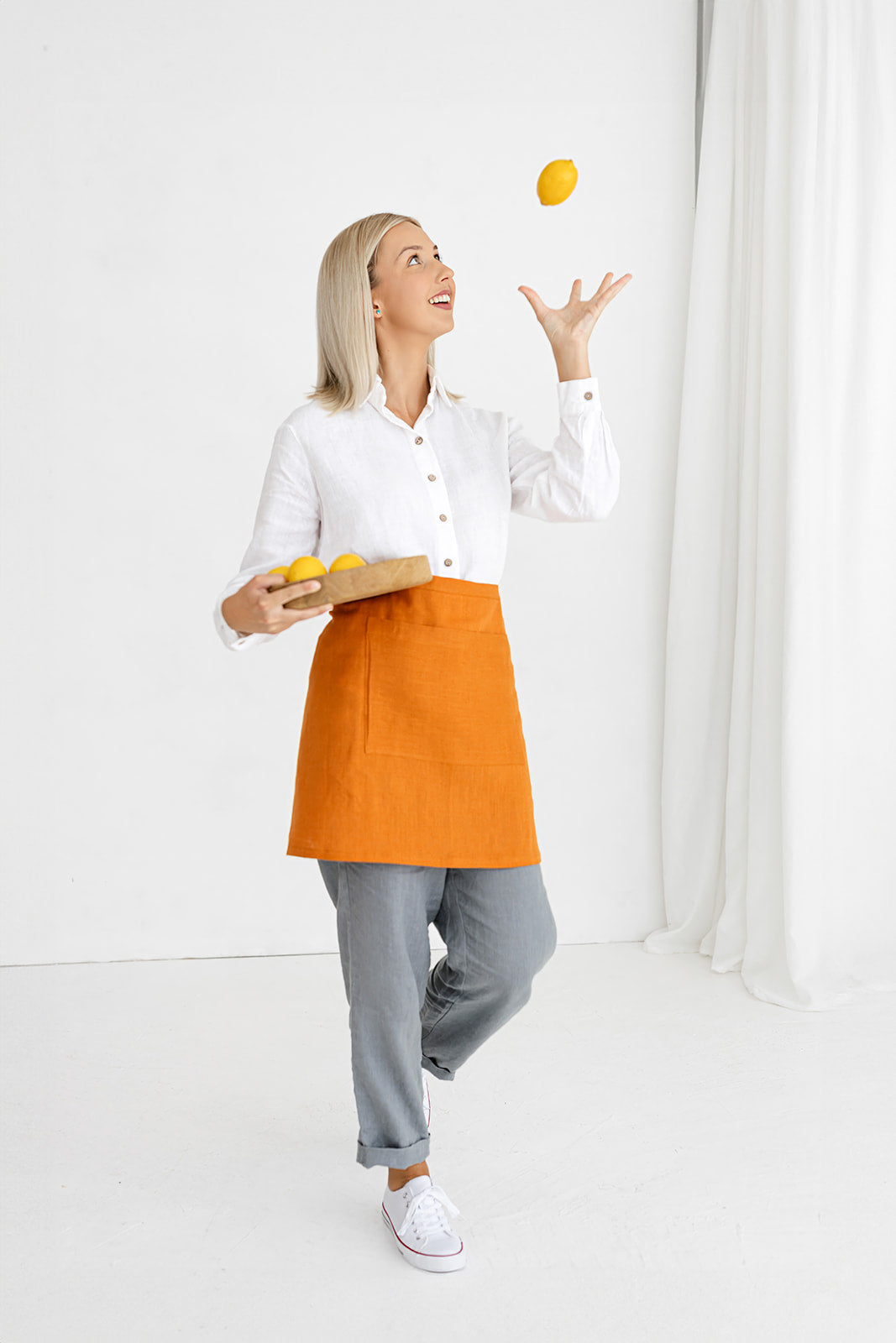 Model Demonstrates Linen Half Apron In Mustard Color Made By Daily Linen