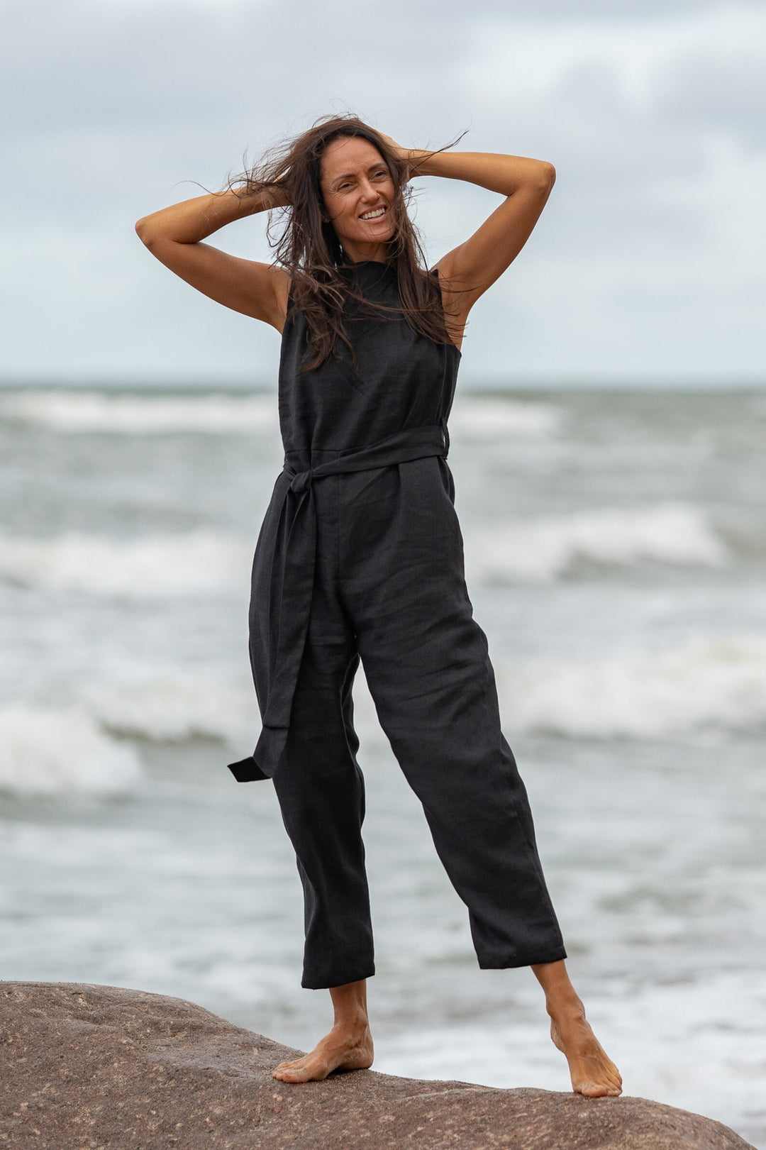 Model In Beach Demonstrates Linen Wrap Junpsuit Dicey In Black Color - Daily Linen