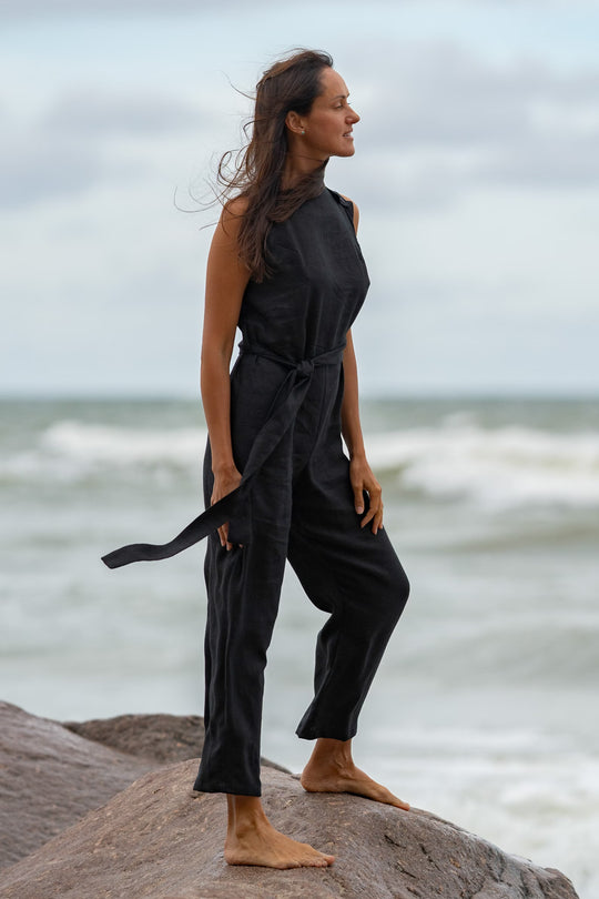 Model In Beach Demonstrates Linen Wrap Jumpsuit Dicey In Black Color 1 - Daily Linen
