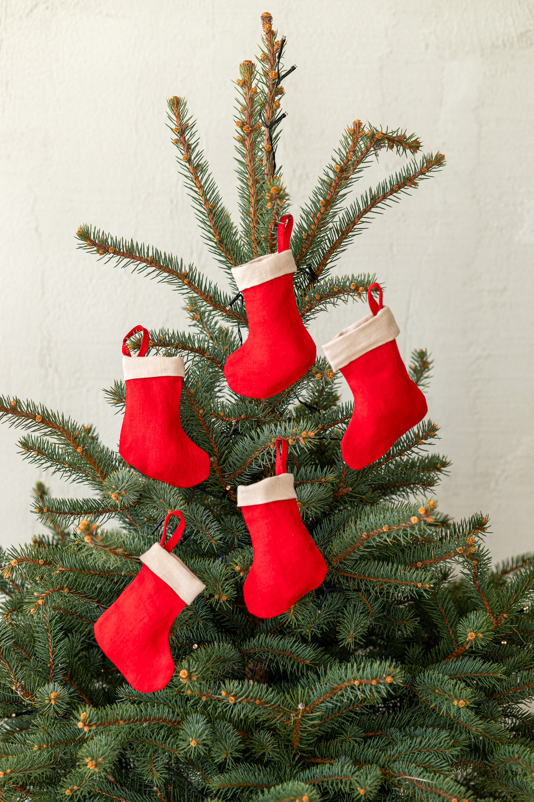 Set Of 5 Linen Christmas Stockings In Red Color Hanging On Tree - Daily Linen