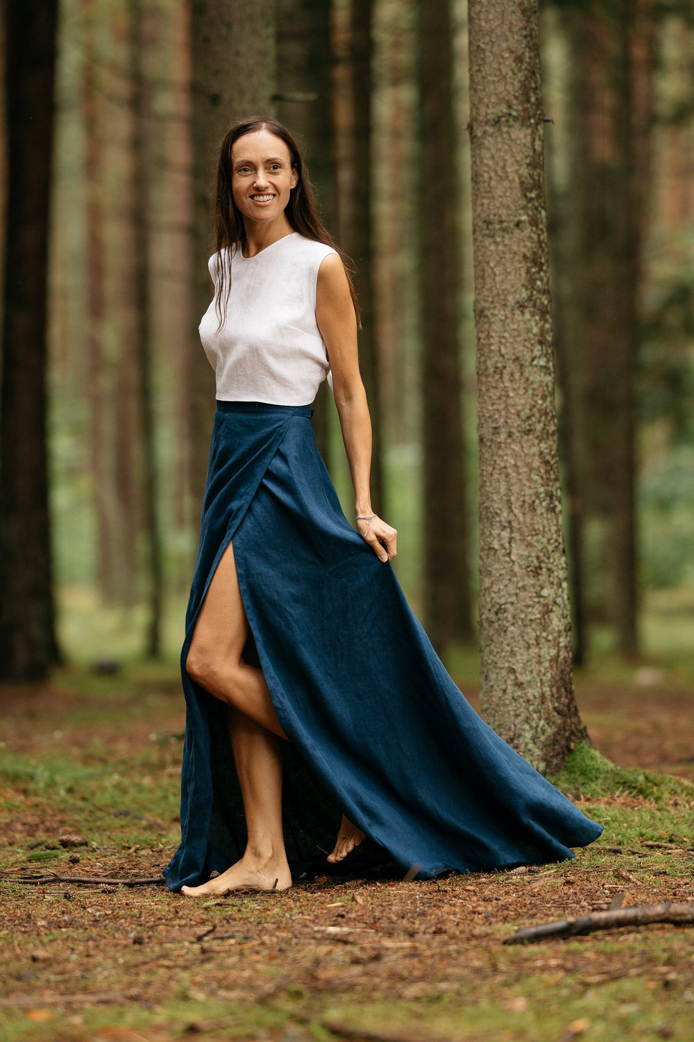 Model In Forest Wears Linen Wrap Maxi Skirt In Midnight Blue Color 1 - Daily Linen